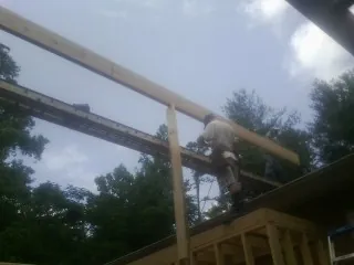 Carpenter setting a ridge beam over a new addition frame — Ice Dam Removal by Roofing Brothers in Ocean Gate