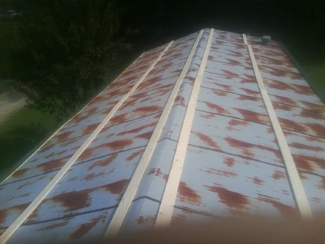 Rusted metal roof panels with new wood purlins before replacement — Storm Damage Roof Repair in Ocean Gate by Roofing Brothers