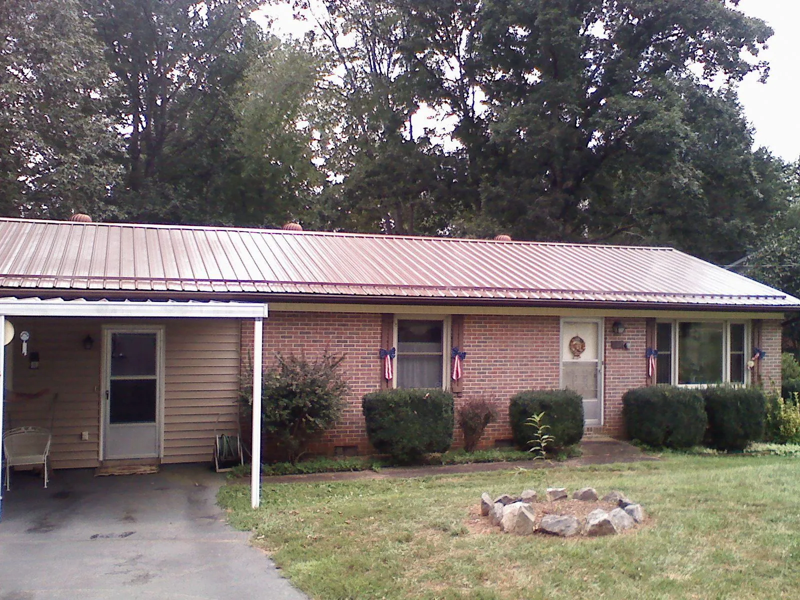 Bronze metal roof and carport on a brick ranch home — Roof Repair work by our crew in Ocean Gate